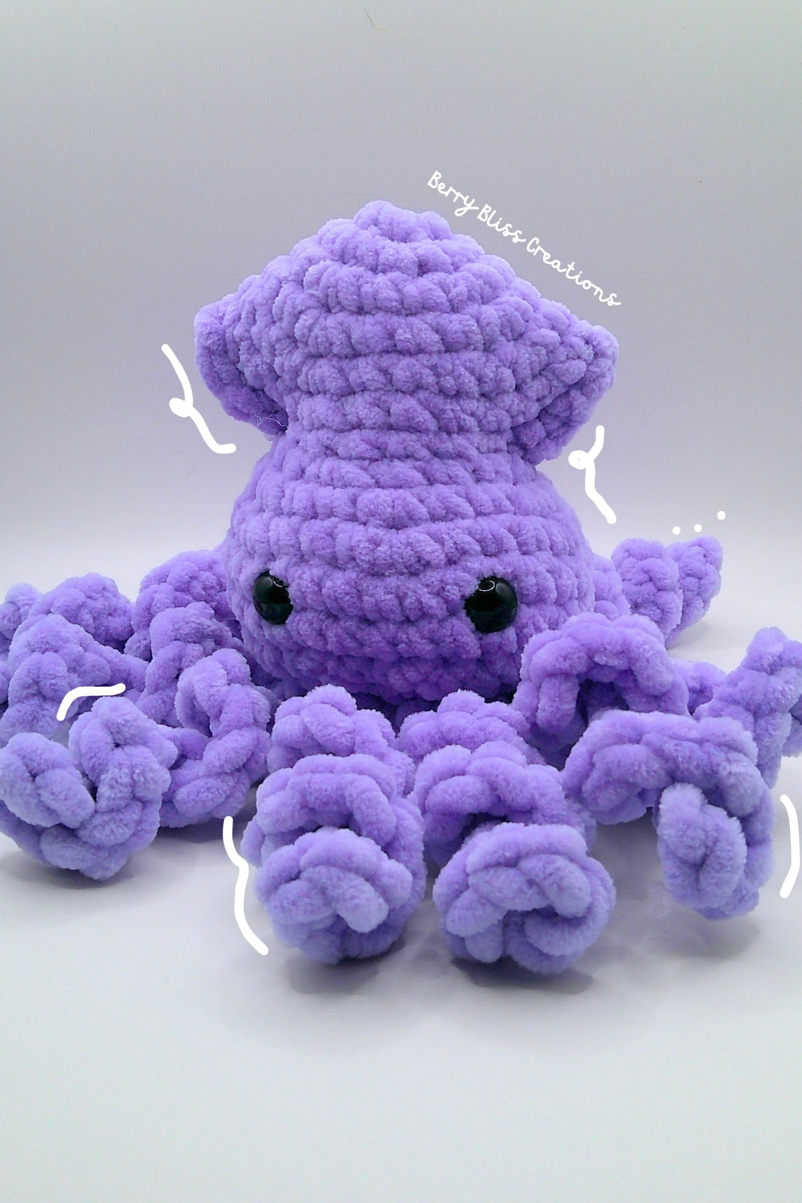 A purple crocheted octopus plush toy with black bead eyes.